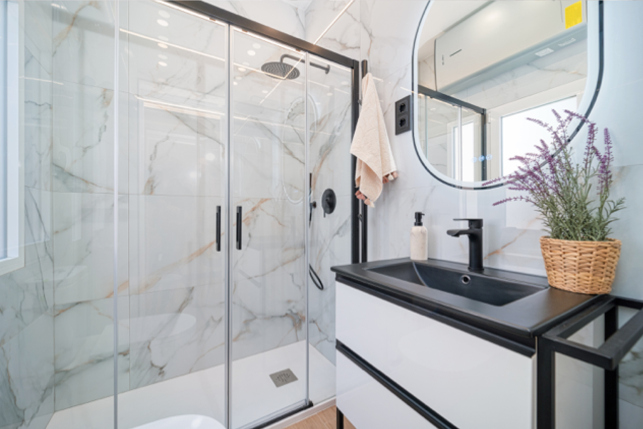 Baño reformado con revestimiento efecto mármol y grifería negra
