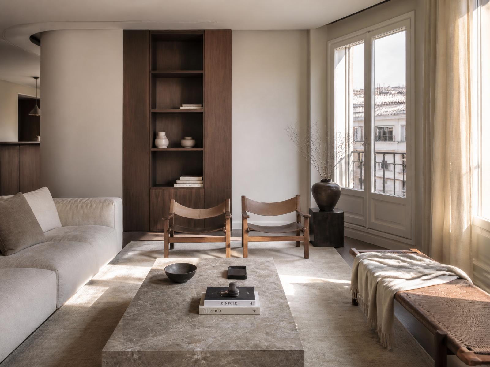 Salón reformado en Madrid con carpintería de nogal, mármol taupe y luz natural